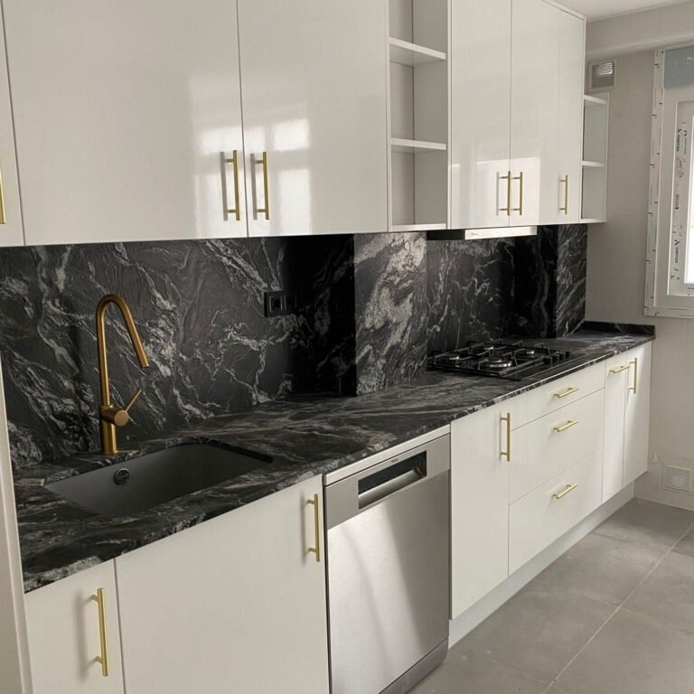 Cocina blanco brillo con asas doradas y encimera porcelánico negro