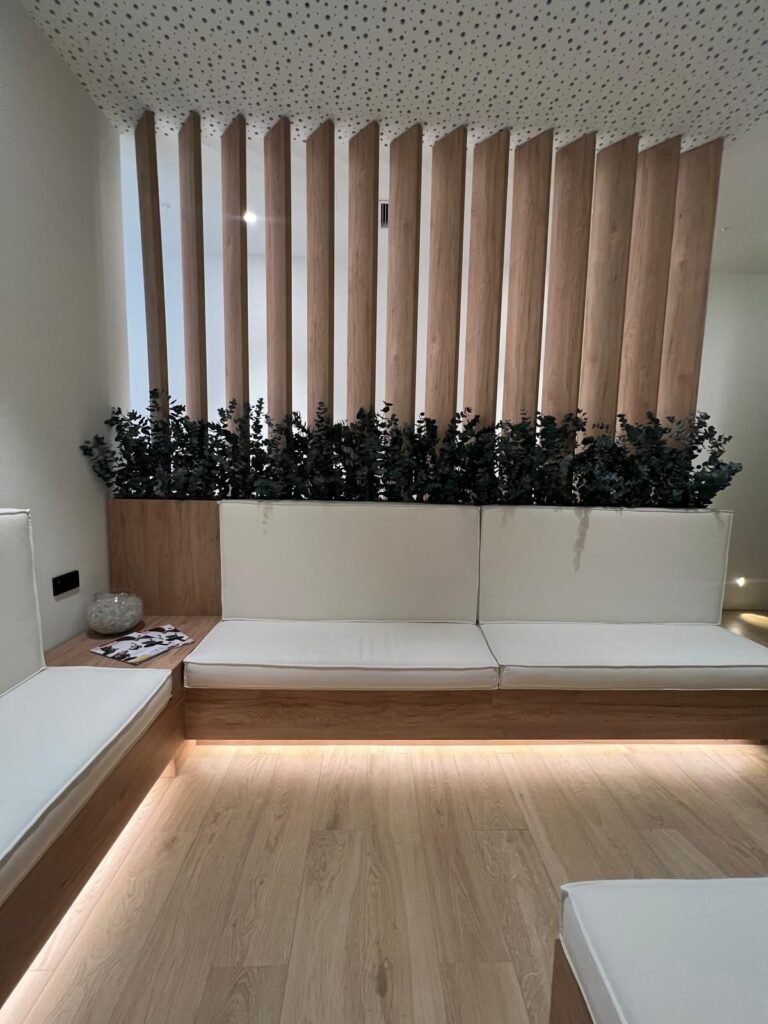Sala de espera con lamas suelo a techo e iluminación cálida
