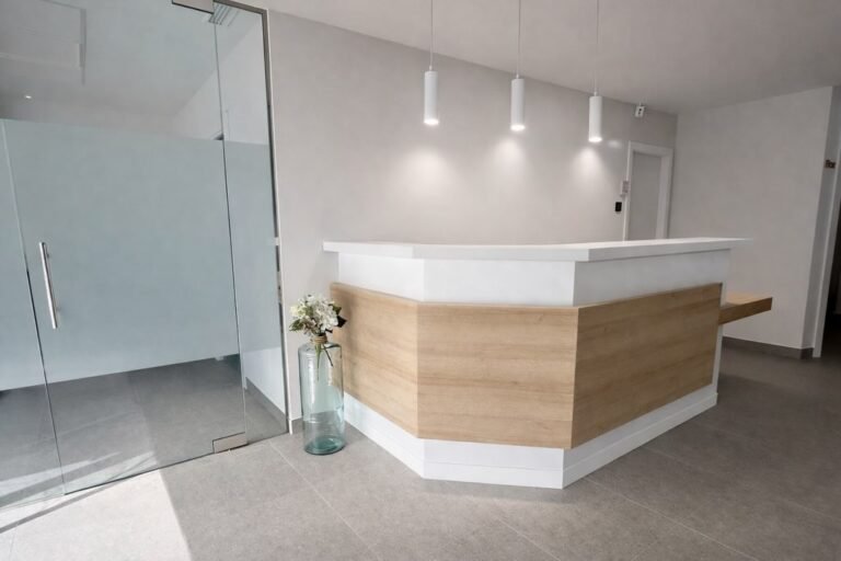 Mostrador de recepción dental en blanco y madera con zona accesible
