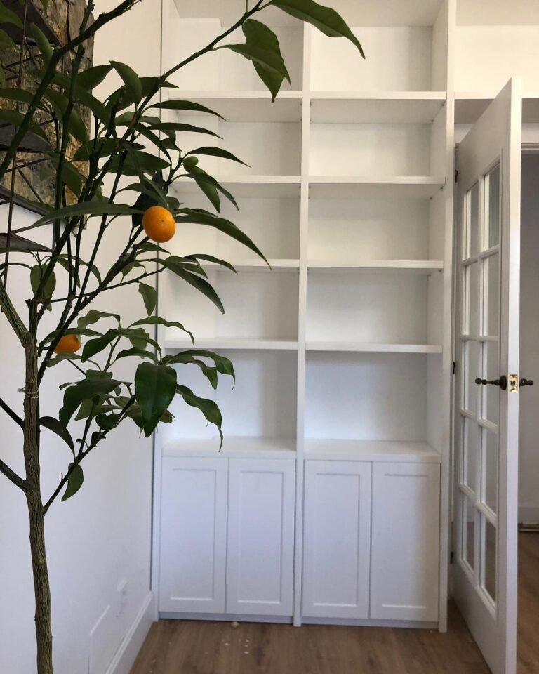 Librería lacada blanca a medida integrada con doble puerta de paso