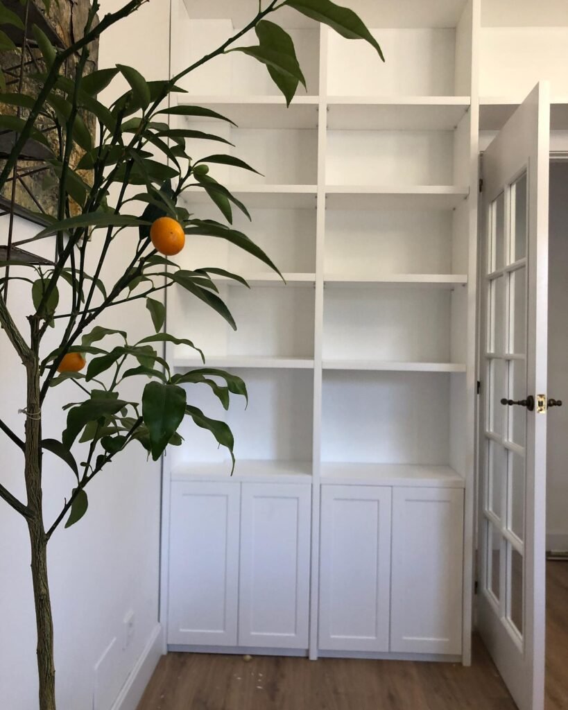 Librería con formas cúbicas y material de 30 mm de calidad 4 Librería lacada blanca a medida integrada con doble puerta de paso