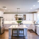Cocina blanca aspiracional con isla central diseñada en 3D y validada con realidad virtual antes de fabricar