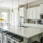 Cocina blanca reformada en Zaragoza con isla central, encimera de cuarzo blanco y muebles altos en color blanco